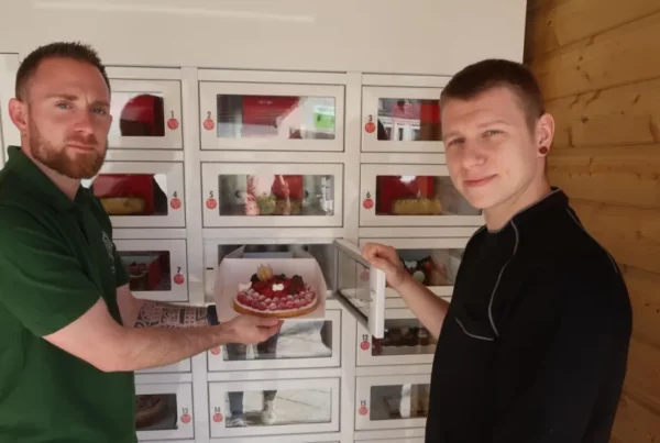 Nos 2 associés de la pâtisserie HB devant leur distributeur automatique