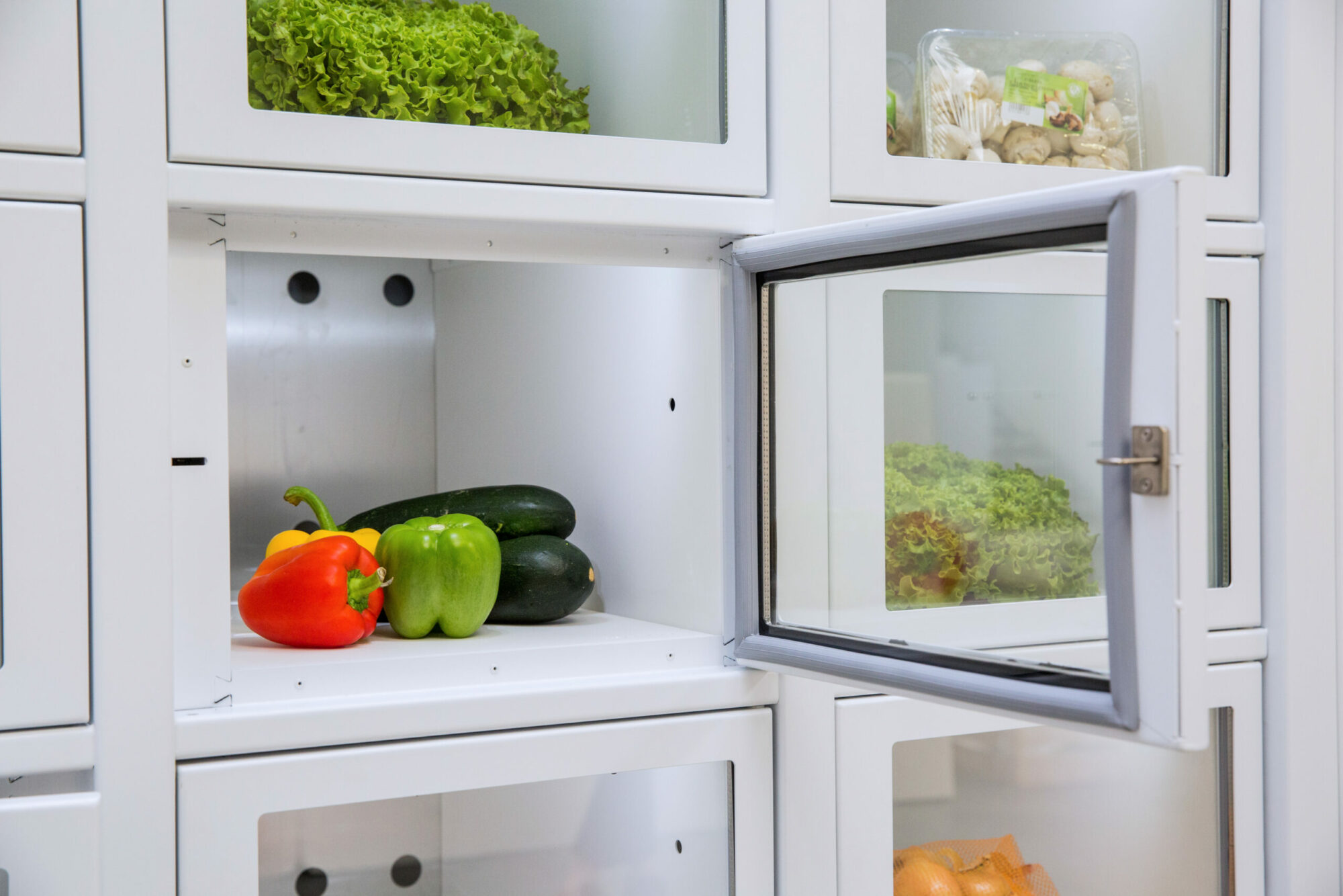 Porte ouverte d'un casier de distributeur automatique Le Casier Français avec des légumes à l'intérieur