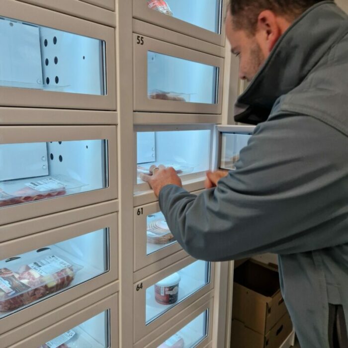 Mr Petit, gérant du P'tit marché des Melayons qui remplit ses casiers