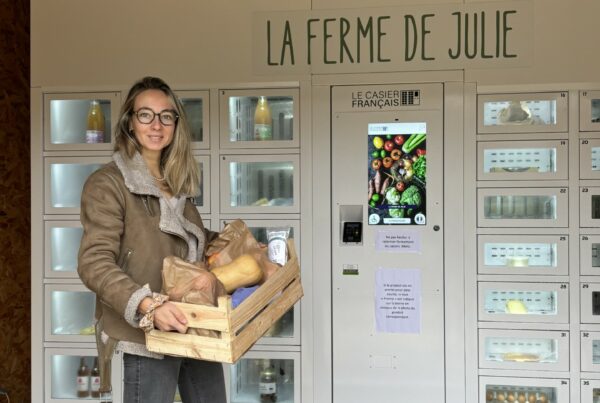 Julie posant devant ses casiers connectés à la ferme.