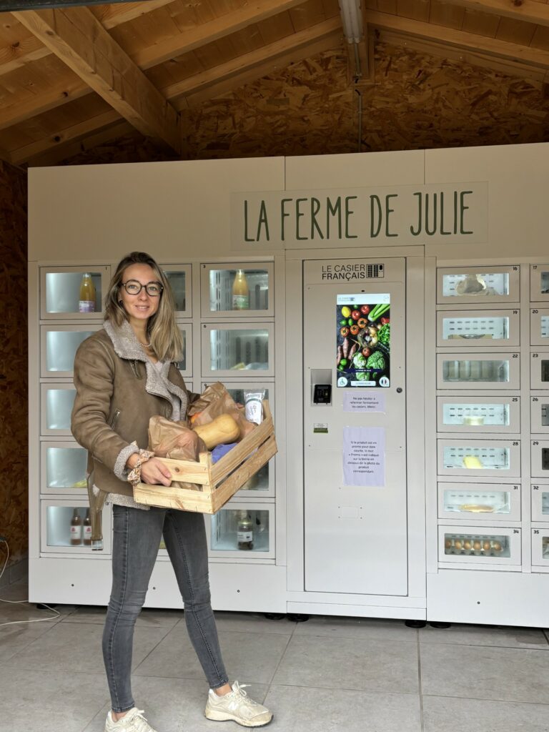 Julie posant devant ses casiers connectés à la ferme.