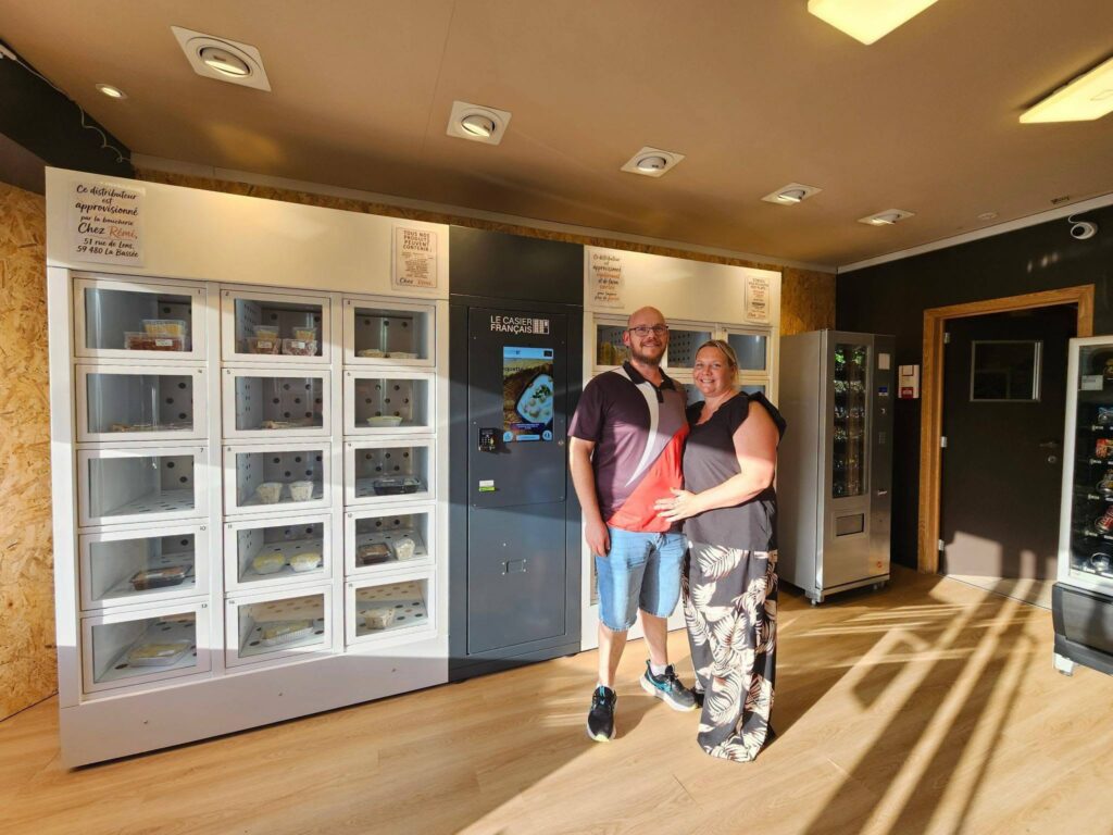Le couple de traiteurs pose devant les casiers automatiques alimentaires